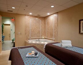 Spa with jacuzzi and massage tables at Embassy Suites By Hilton Charlotte-Concord-Golf Resort & Spa.