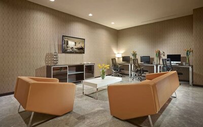 Business center with computers,ergonomic chairs and lounge area at EB Hotel Miami.