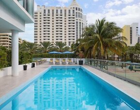 Outdoor pool with lounge seating at Hyatt Centric Miami South Beach.