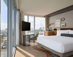 King room with floor to ceiling windows, work desk, TV screen and private bathroom at Hyatt Centric Miami South Beach.