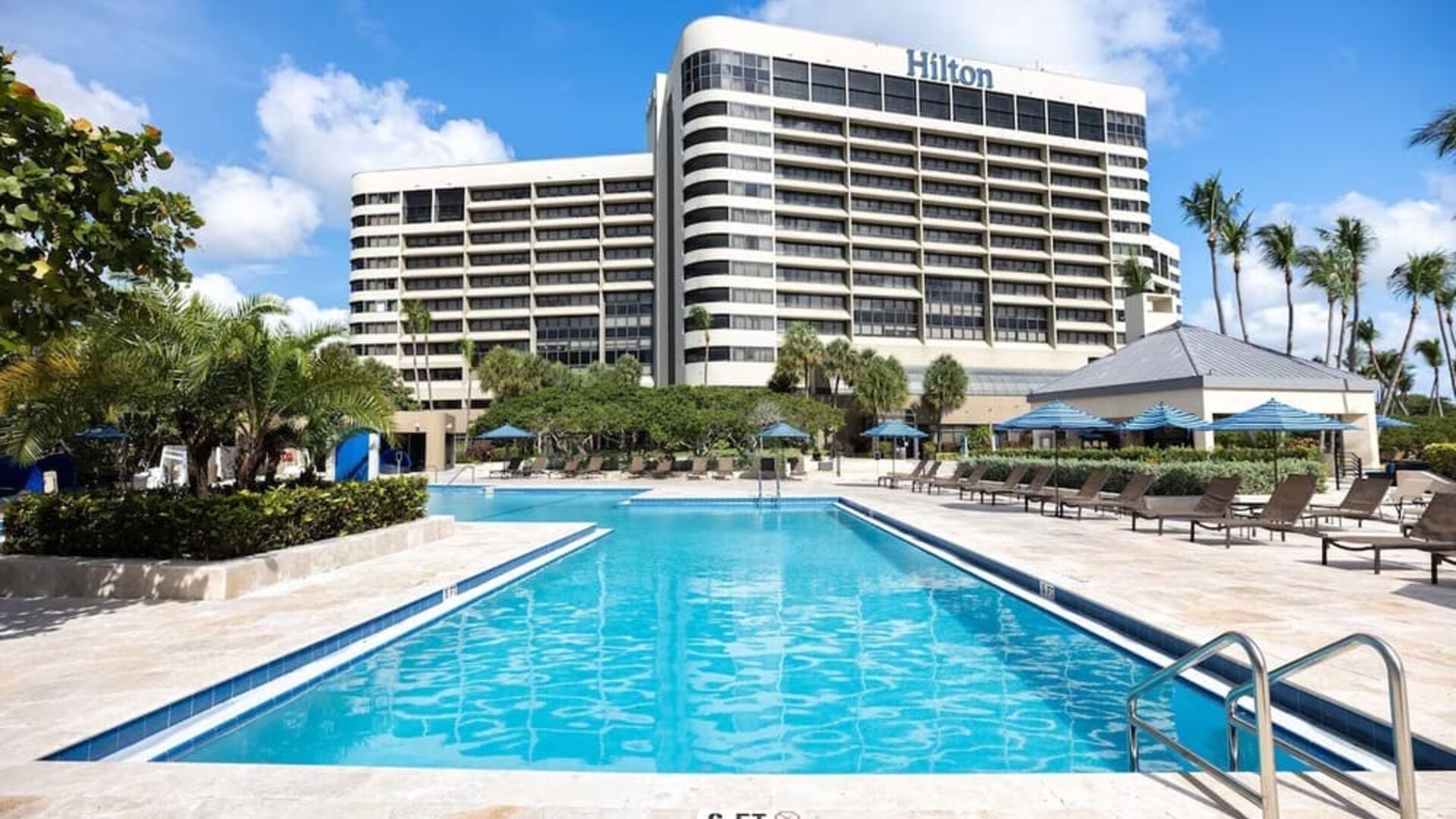 Outdoor pool with lounge seating at Hilton Miami Airport Blue Lagoon.
