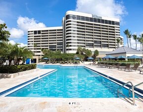 Outdoor pool with lounge seating at Hilton Miami Airport Blue Lagoon.