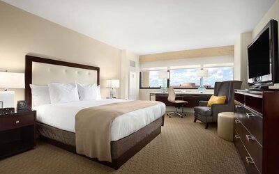 Day use room with work desk, TV screen, private bathroom and large windows at Hilton Miami Airport Blue Lagoon.