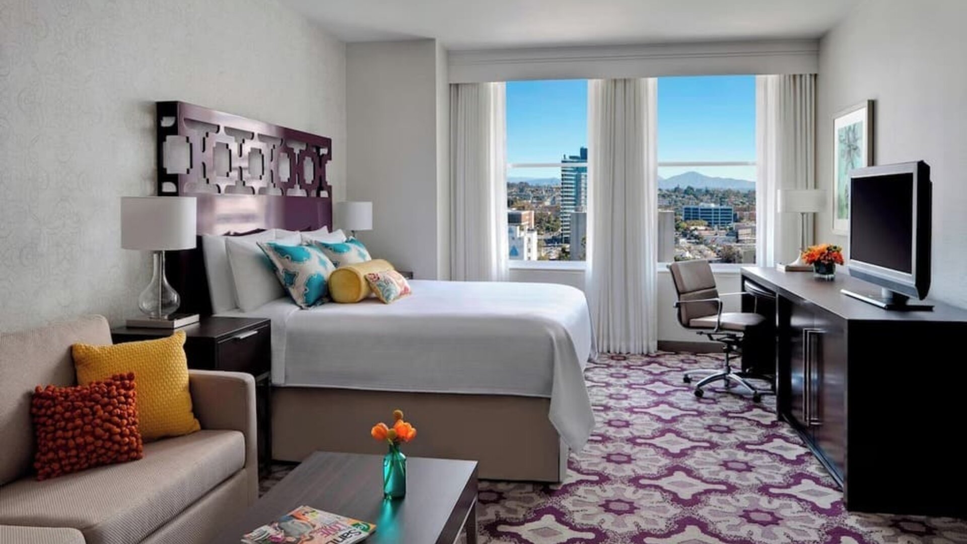 Day use room with TV, work desk, sofa and natural light at Courtyard San Diego Downtown.