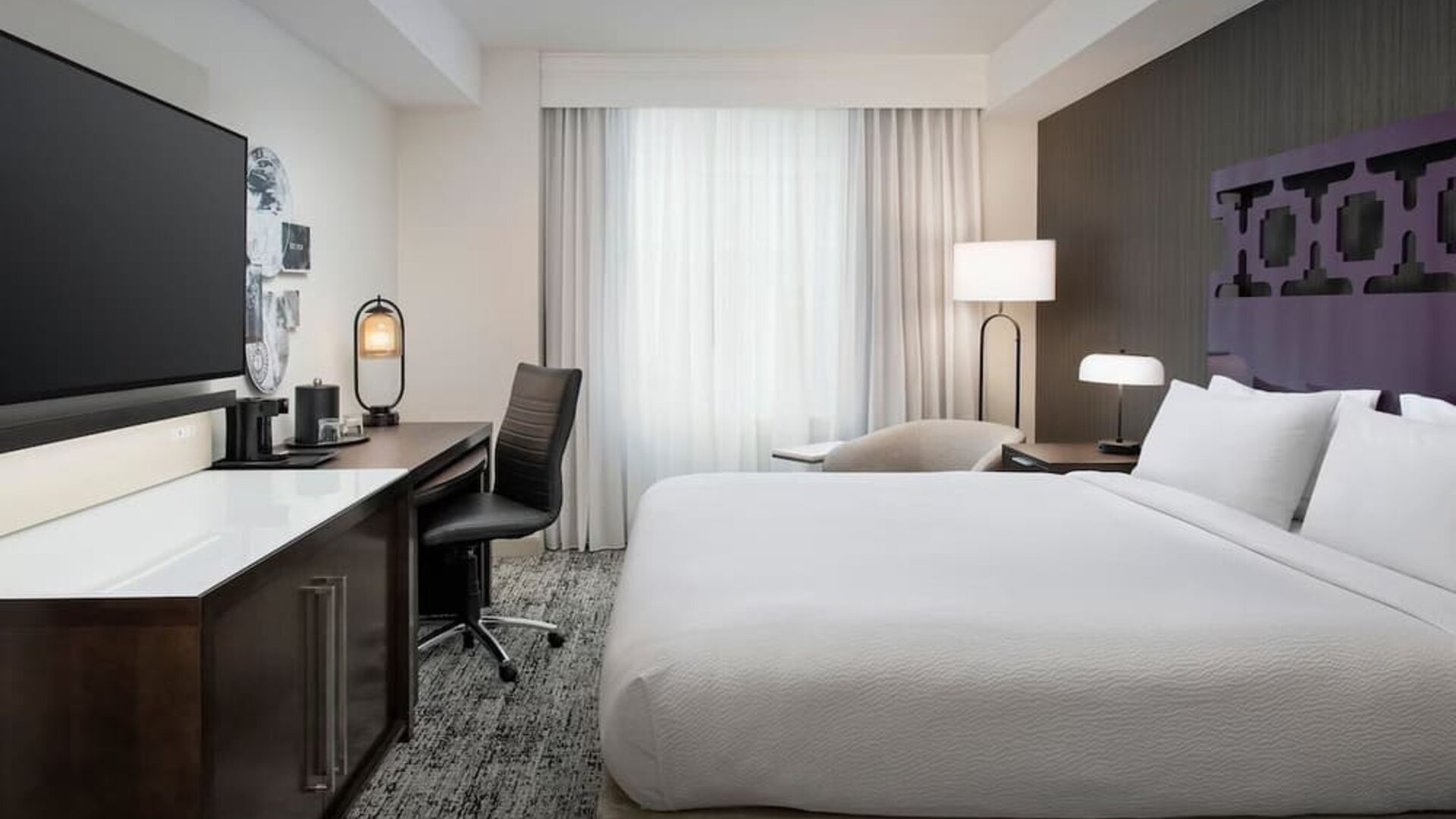 Delux king room with TV, work desk, and natural light at Courtyard San Diego Downtown.