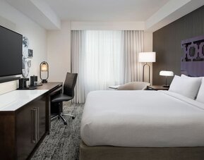 Delux king room with TV, work desk, and natural light at Courtyard San Diego Downtown.