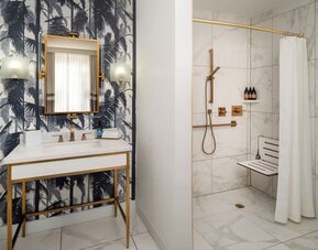 Accessible private guest bathroom with shower at Cadillac Hotel & Beach Club, Autograph Collection.