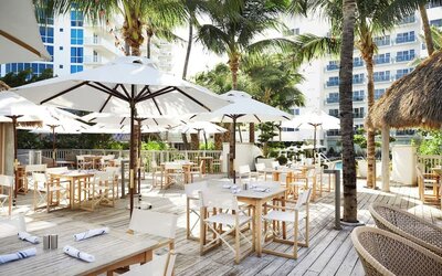 Outdoor lounge and dining area with comfortable seating at Cadillac Hotel & Beach Club, Autograph Collection.
