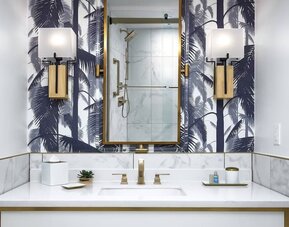 Private guest bathroom with shower and free toiletries at Cadillac Hotel & Beach Club, Autograph Collection.