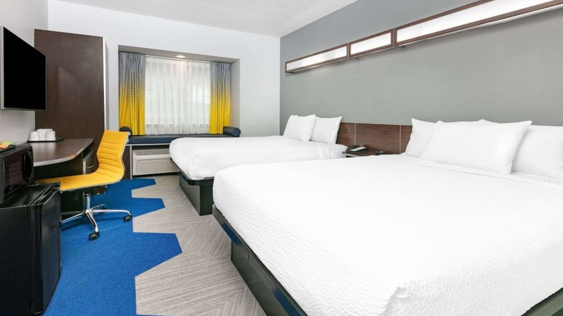 Day use room with TV and work desk at Microtel Inn And Suites By Wyndham Austin Airport.