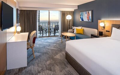 King bedroom with desk and balcony at Hyatt Regency San Francisco.
