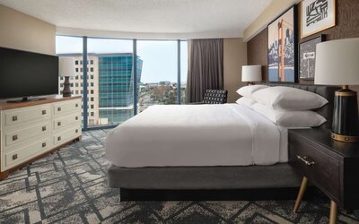 King size bed, TV and large window at Embassy Suites by Hilton San Francisco Airport.