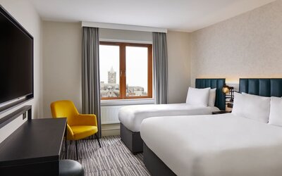Two beds with TV at Leonardo Hotel Dublin Christchurch.
