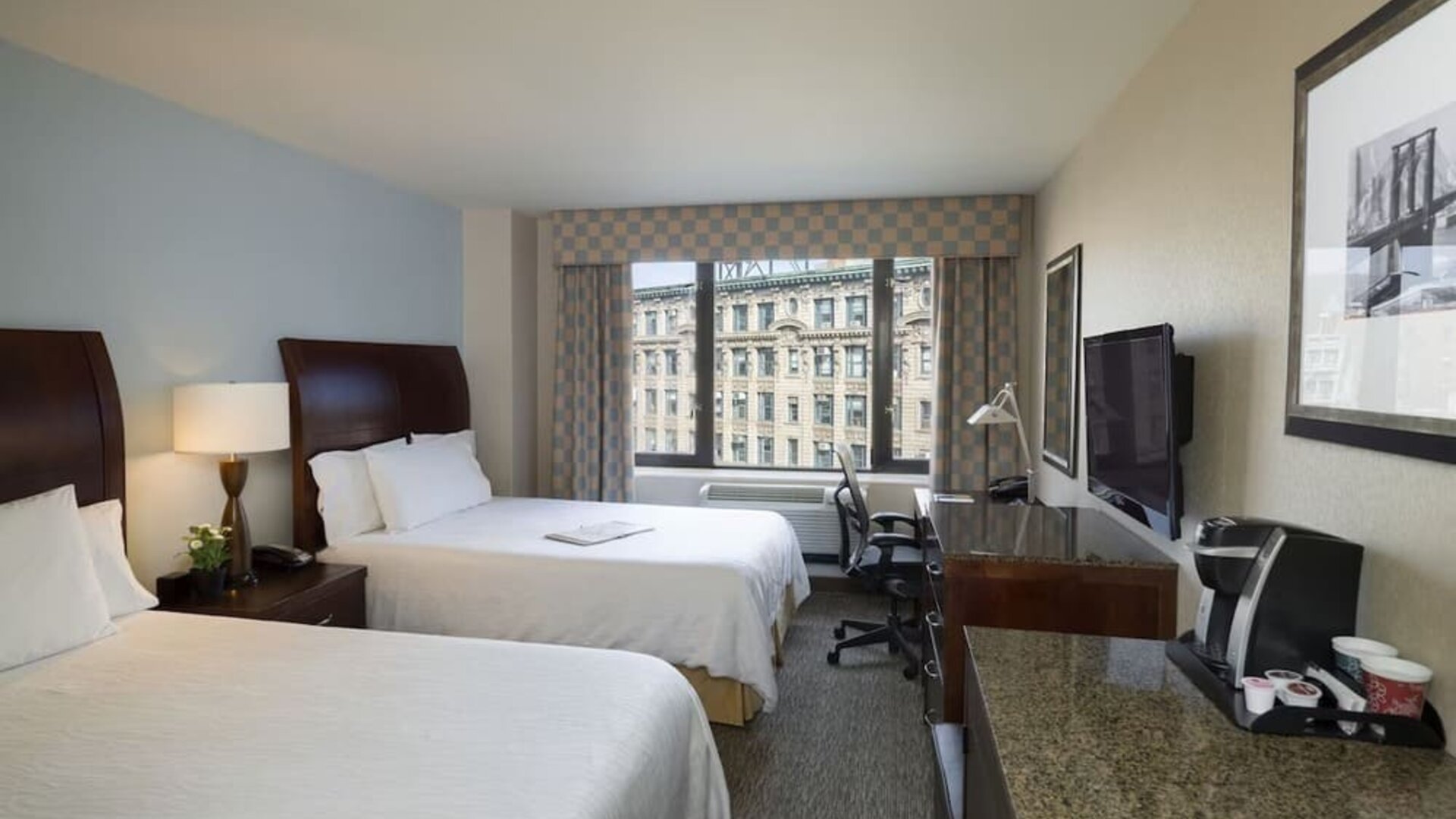 Guest room with two beds and a functional workspace at Hilton Garden Inn Tribeca.