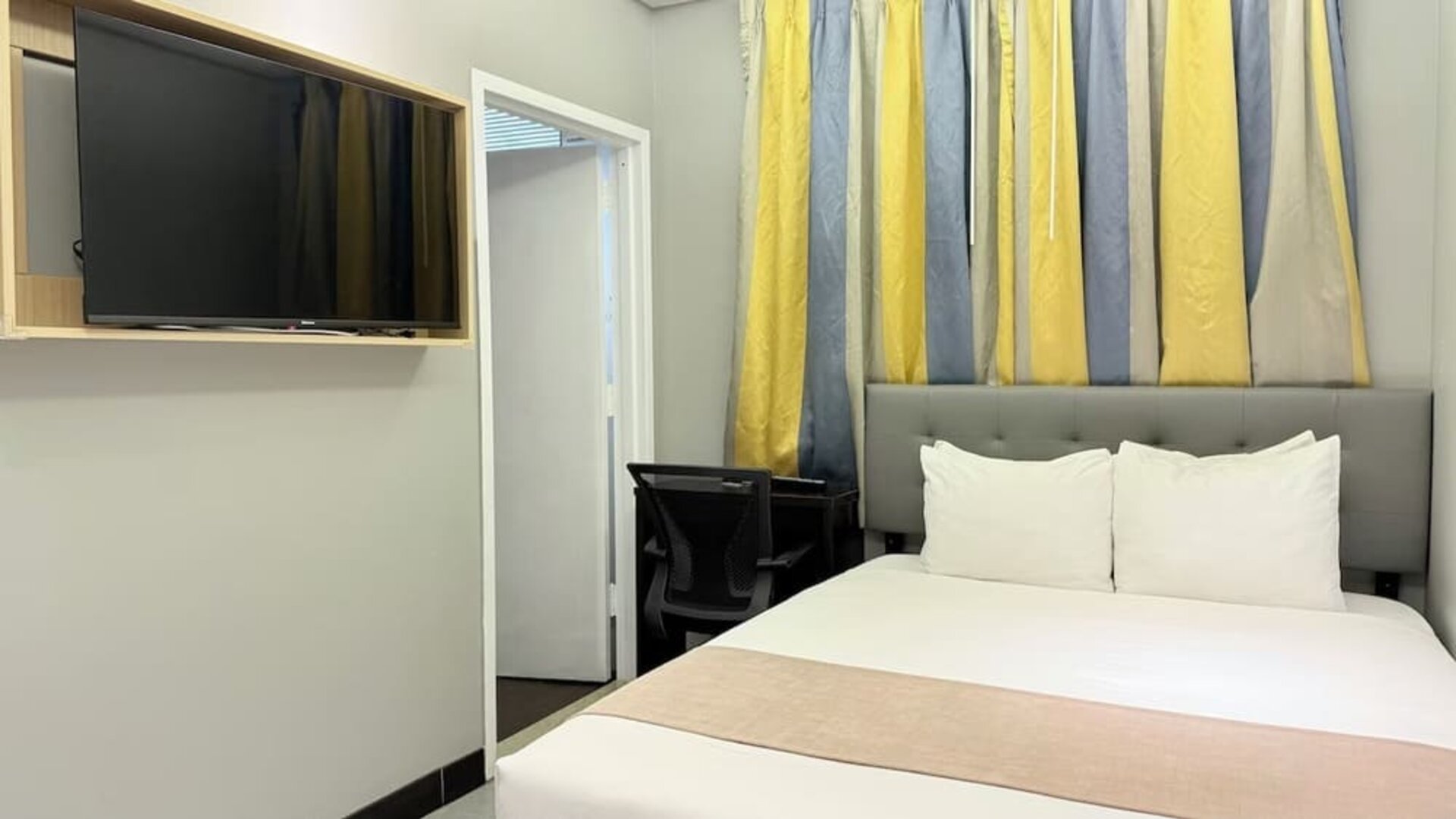 Madison LES Hotel room with double bed, and desk for working.