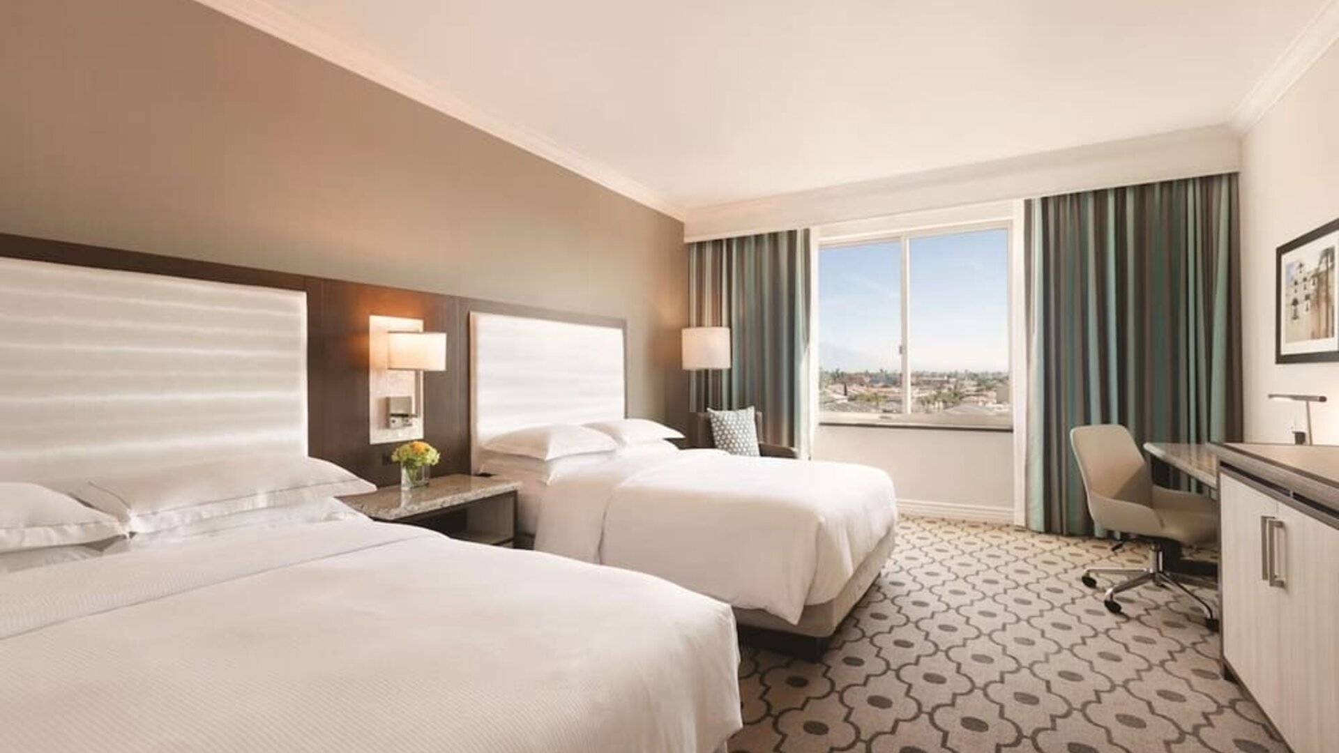 Comfortable day room with natural light, desk and chair at Hilton Los Angeles/San Gabriel for a relaxing daycation.