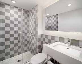 Guest bathroom with shower at Best Western Premier Empire State Hotel.