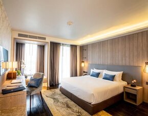 Day room with work desk and chair and natural light at Divalux Resort & Spa Bangkok Suvarnabhumi Airport.