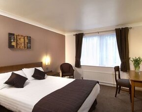 Day room with workspace and natural light at The Old Golf House Hotel.