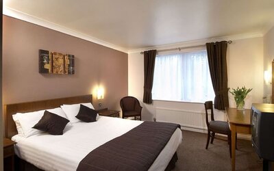 Day room with workspace and natural light at The Old Golf House Hotel.