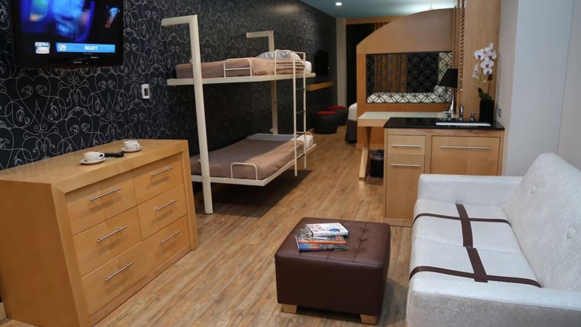 Room at the TRYP By Wyndham Times Square South containing desk, double bed, bunk beds and a couch.