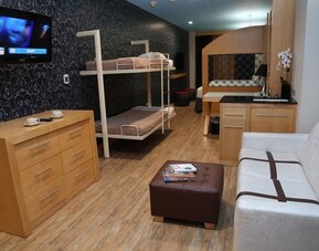 Room at the TRYP By Wyndham Times Square South containing desk, double bed, bunk beds and a couch.