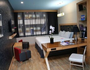 Room at the TRYP By Wyndham Times Square South containing desk, bed, and a television.