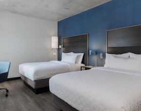 Two beds with work chair and desk at Tru By Hilton Montreal Centre-Ville.