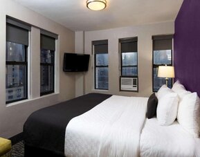 Day use room with a television and a view of the city at La Quinta Inn & Suites By Wyndham New York City Central Park.