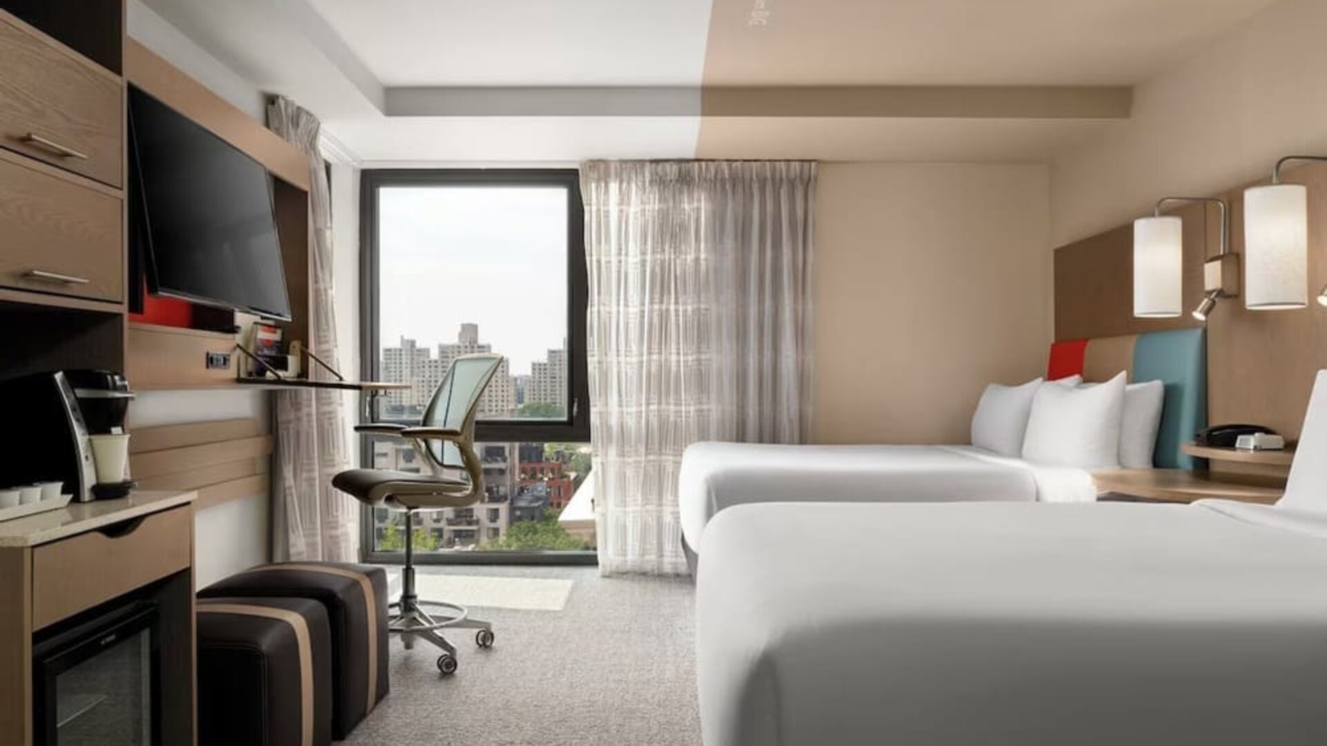 Day room featuring a desk and chair, with large windows offering beautiful city views at EVEN Hotel Brooklyn By IHG.