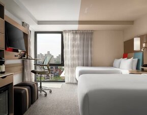 Day room featuring a desk and chair, with large windows offering beautiful city views at EVEN Hotel Brooklyn By IHG.