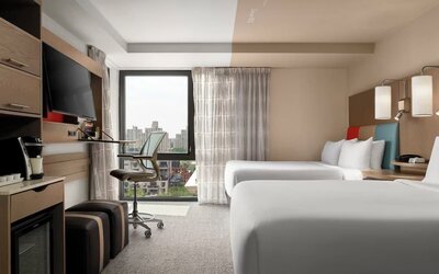 Day room featuring a desk and chair, with large windows offering beautiful city views at EVEN Hotel Brooklyn By IHG.