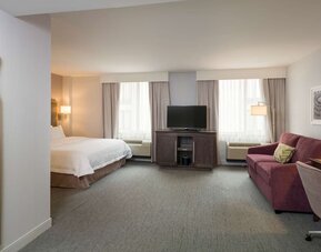 Day use room with a couch. work desk and chair at the Hampton Inn Times Square South. 