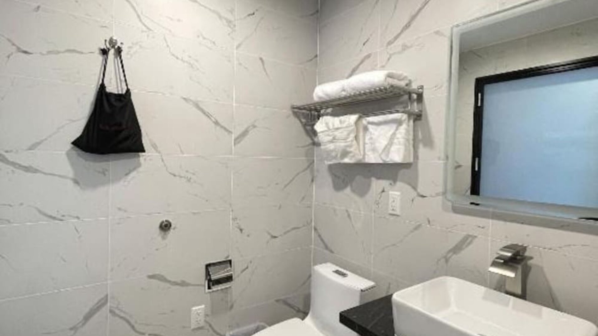 Modern bathroom with plush towels at Liberty View Brooklyn Hotel.