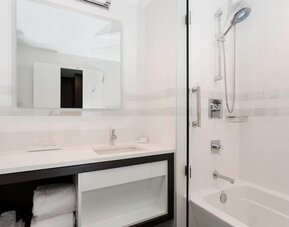 Modern bathroom with plush towels at Courtyard By Marriott Long Island City/New York Manhattan View.