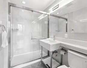 Modern bathroom with towels at Hotel 365 Bronx.