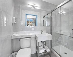 Modern bathroom with towels at Hotel 365 Bronx.