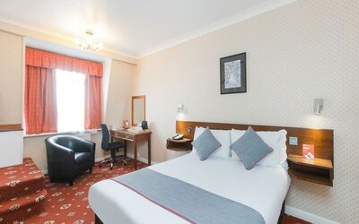 Day room with workspace and a couch at Stade Court Hotel.