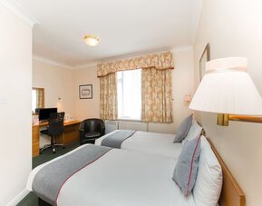 Day room with workspace and a couch at Stade Court Hotel.