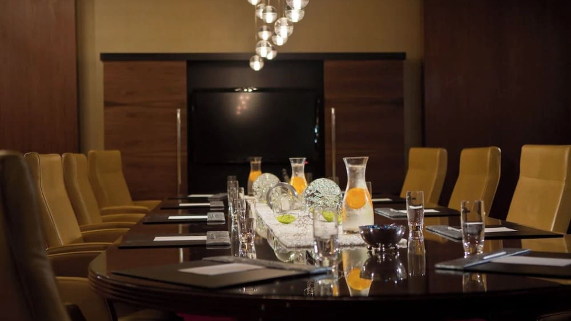 Boardroom with long table, chairs and decorative lighting at Renaissance Newark Airport Hotel.