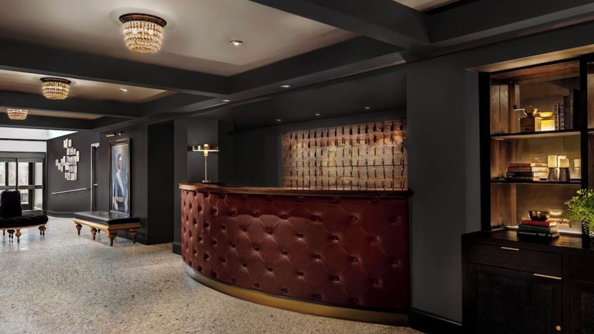 Lobby reception with curved leather desk, chandelier lighting, and seating at Kimpton Palladian Hotel.