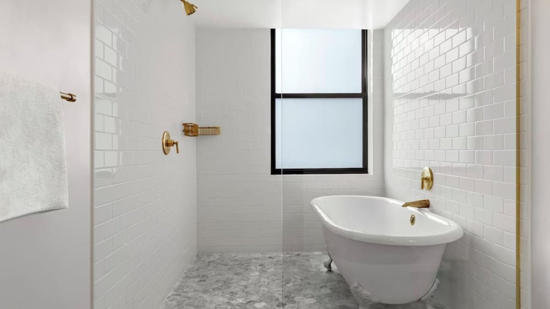Bathroom with freestanding clawfoot tub, white tile walls, and brass fixtures at Kimpton Palladian HotelTwin bedroom with two beds, framed artwork, wall-mounted TV, and natural light at Kimpton Palladian Hotel.