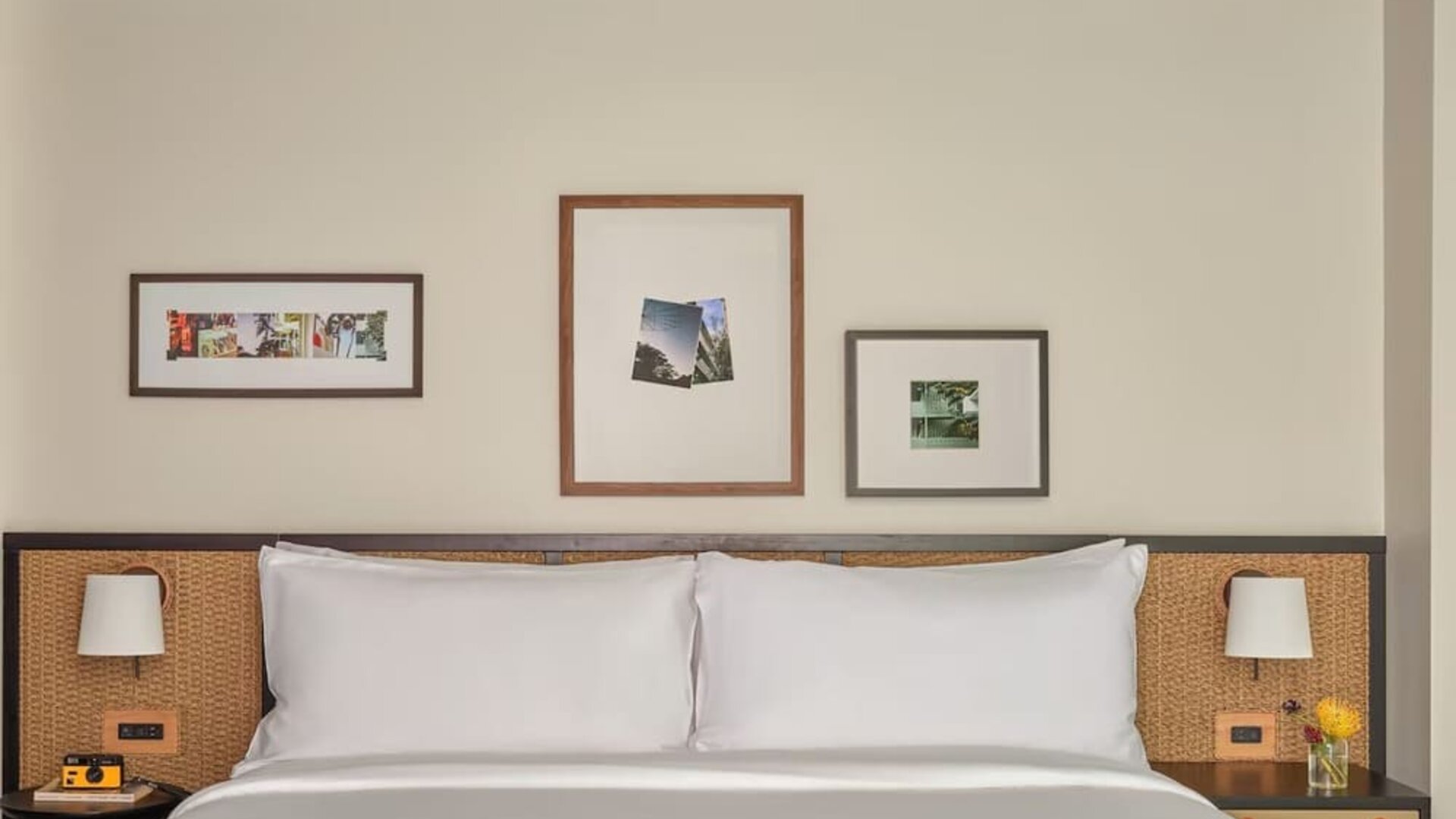 King bed centered in room with bedside tables, framed artwork, and neutral tones creating a calm space at Romer House Waikiki.