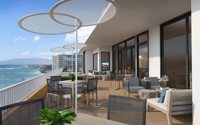 Large terrace with dining tables, lounge seating, and panoramic oceanfront views at The Twin Fin Hotel.