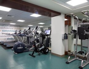 Fitness center with treadmills, elliptical machines, and mirrored walls at The Twin Fin Hotel.