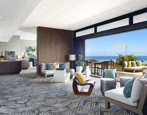 Open lounge with ocean-view terrace seating and modern indoor furnishings at The Twin Fin Hotel.