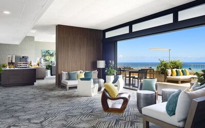 Open lounge with ocean-view terrace seating and modern indoor furnishings at The Twin Fin Hotel.
