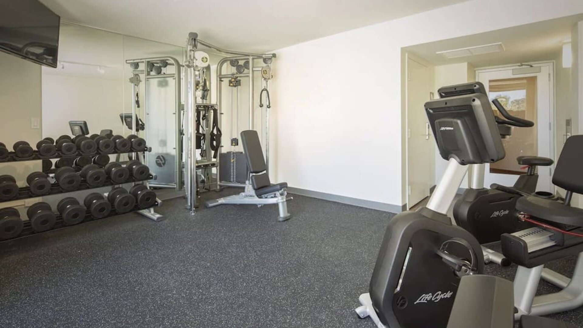 Fitness center with free weights, cable machine, and exercise bike at Park Shore Waikiki.