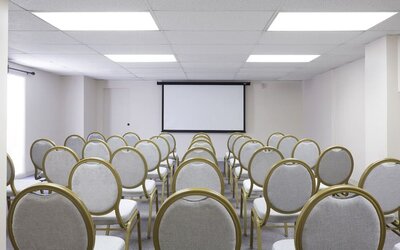 Meeting room with rows of chairs facing a presentation screen at Park Shore Waikiki.