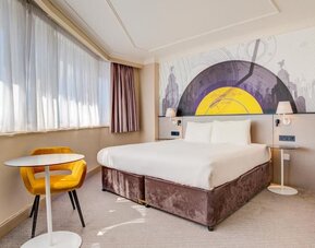 Spacious double room with large bed, side tables, and seating area by the window at Atlantic Tower Hotel Liverpool By Sunday.